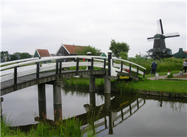 암스테르담 중앙 역에서 알크마르 방면 보통열차를 타고 코흐잔디크 Koog Zaandijk에 하차, 역에서 도보로 15분 걸린다.   

네덜란드 명물인 풍차와 양의 방목이 유명하고 전형적인 네덜란드의 풍경을 간직한 곳으로 암스테르담 북서쪽 약 15Km 잔(Zaan) 지방의 잔 강변에 있는 작은 마을이다. 잔 강을 건너면 왼쪽에 보트 승강장과 풍차가 나타나고 강에서 조금 떨어진 다른 쪽엔 나막신을 만들어 파는 가게와 서민풍의 음식점이 위치해 있다. 또 목장 앞의 치즈 공장에서는 맛있는 우유를 맛볼 수 있고 컬러밀이라는 염료를 만드는 풍차의 내부도 견학할 수 있다. 

18세기에는 700개가 넘는 풍차가 있었으나 지금은 4개 만 남아 관광용으로 명맥을 이어가고 있다. 4개의 풍차는 순서대로 식용유를 만드는 풍차 De Zoeker, 도료를 만드는 풍차 De Kat, 제재용으로 쓰이는 풍차 De Poelenburg, 겨자가루를 빻는 풍차 De Huisman이다.